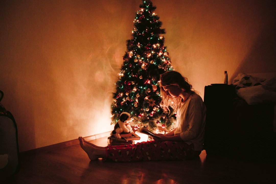 坐在圣诞树旁的女人的照片图片